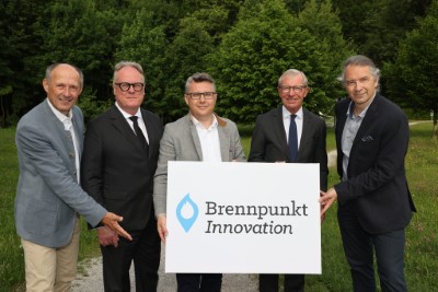 Christian Baumgartner hält mit anderen ein Schild "Brennpunkt Innovation"