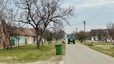 Dorfstraße mit Traktor in einem Dorf an der Donau